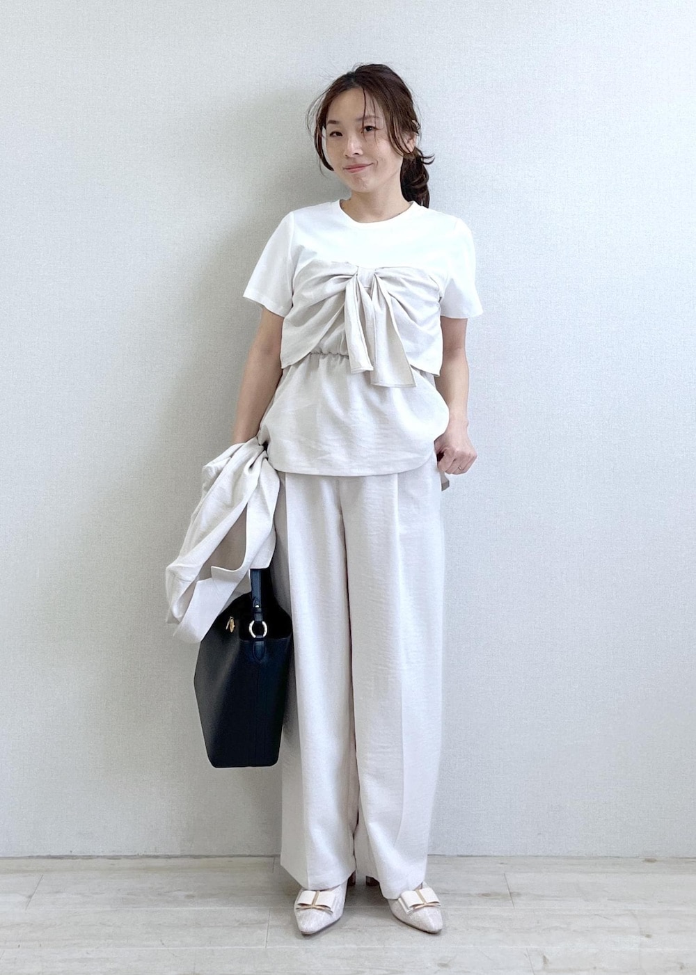 ベージュ系のパンプス、ブラック系のショルダーバッグ、ホワイト系のTシャツ/カットソーを着用したレディースの春コーディネートの6枚目の写真