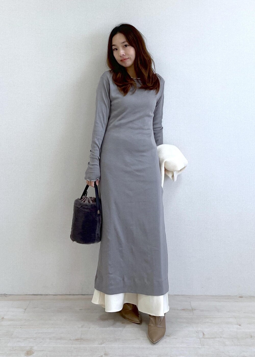 ベージュ系のブーツ、グレー系のショルダーバッグ、ホワイト系のカーディガン/ボレロを着用したレディースの冬コーディネートの7枚目の写真