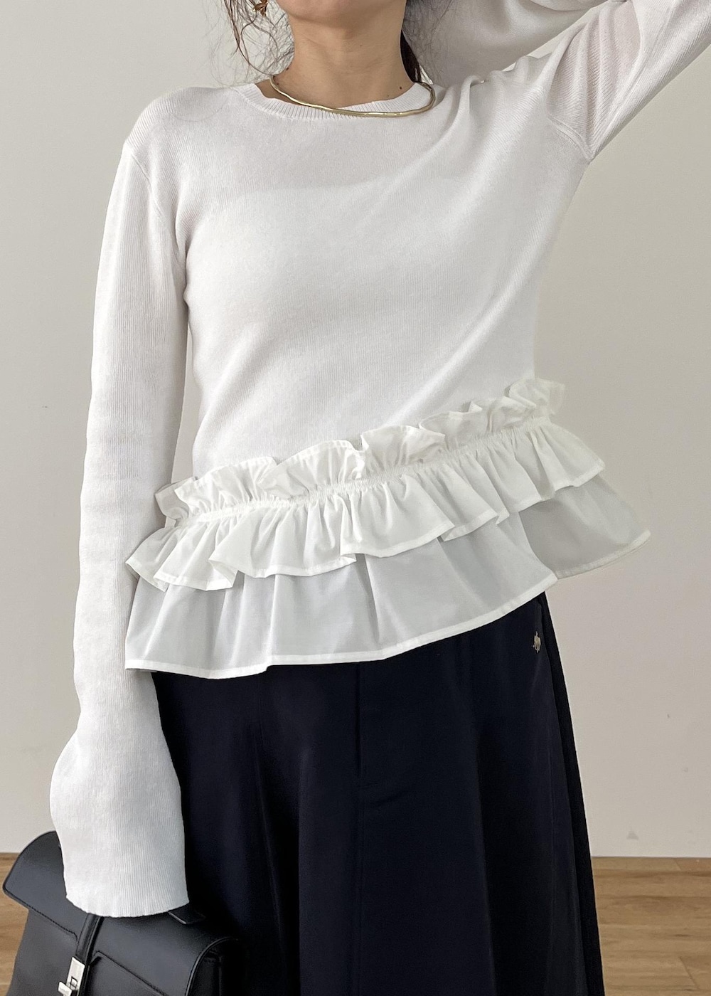 ブラック系のショルダーバッグ、ブラック系のパンプス、ホワイト系のナイロンジャケットを着用したレディースの冬コーディネートの8枚目の写真