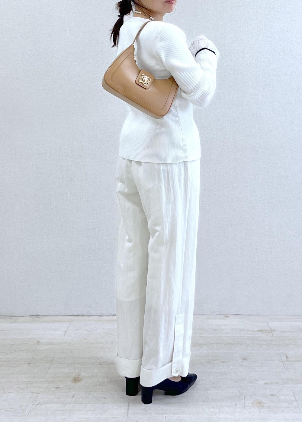 ブラック系のパンプス、ブルー系のテーラードジャケット、イエロー系のショルダーバッグを着用したレディースの冬コーディネートの10枚目の写真