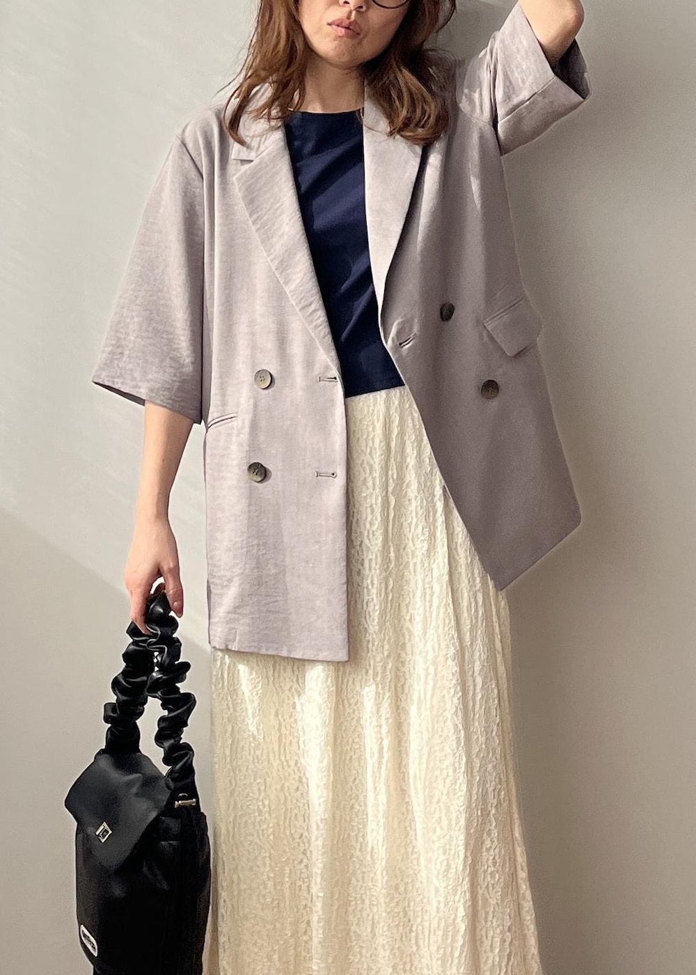 ホワイト系のスカート、ブラック系のショルダーバッグ、ホワイト系のサンダルを着用したレディースの春コーディネートの9枚目の写真