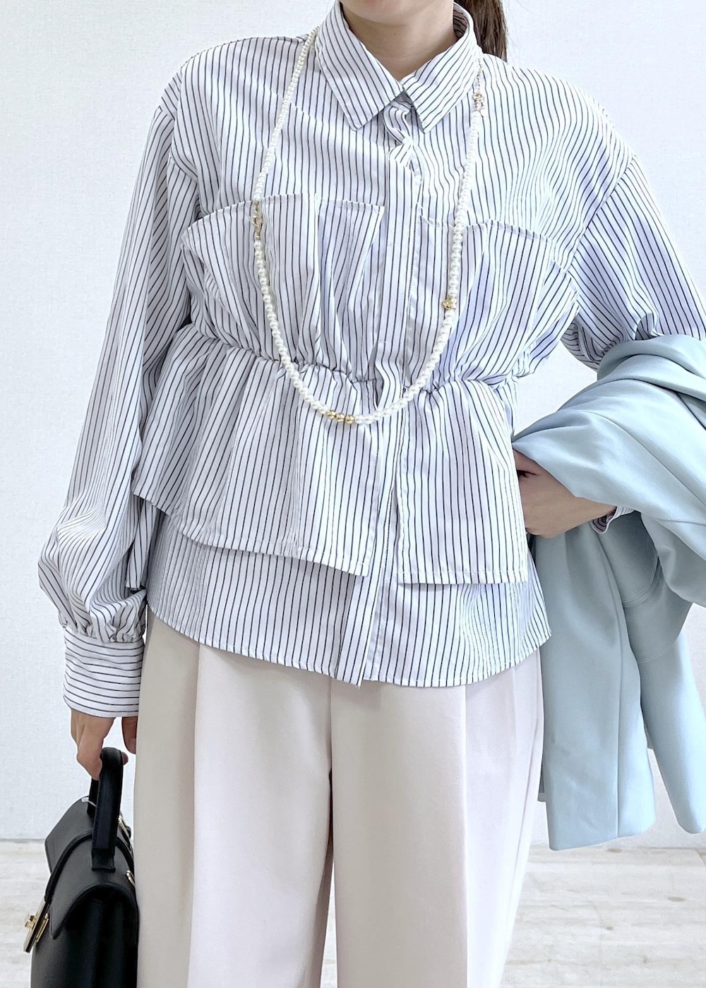 ブラック系のショルダーバッグ、グリーン系のテーラードジャケット、ベージュ系のその他パンツを着用したレディースの春コーディネートの9枚目の写真