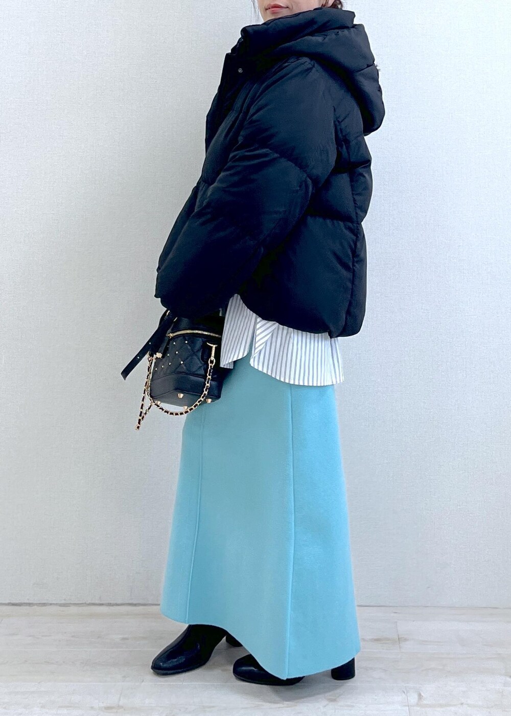 ブラック系のブーツ、ブルー系のスカート、ホワイト系のシャツ/ブラウスを着用したレディースの冬コーディネートの2枚目の写真