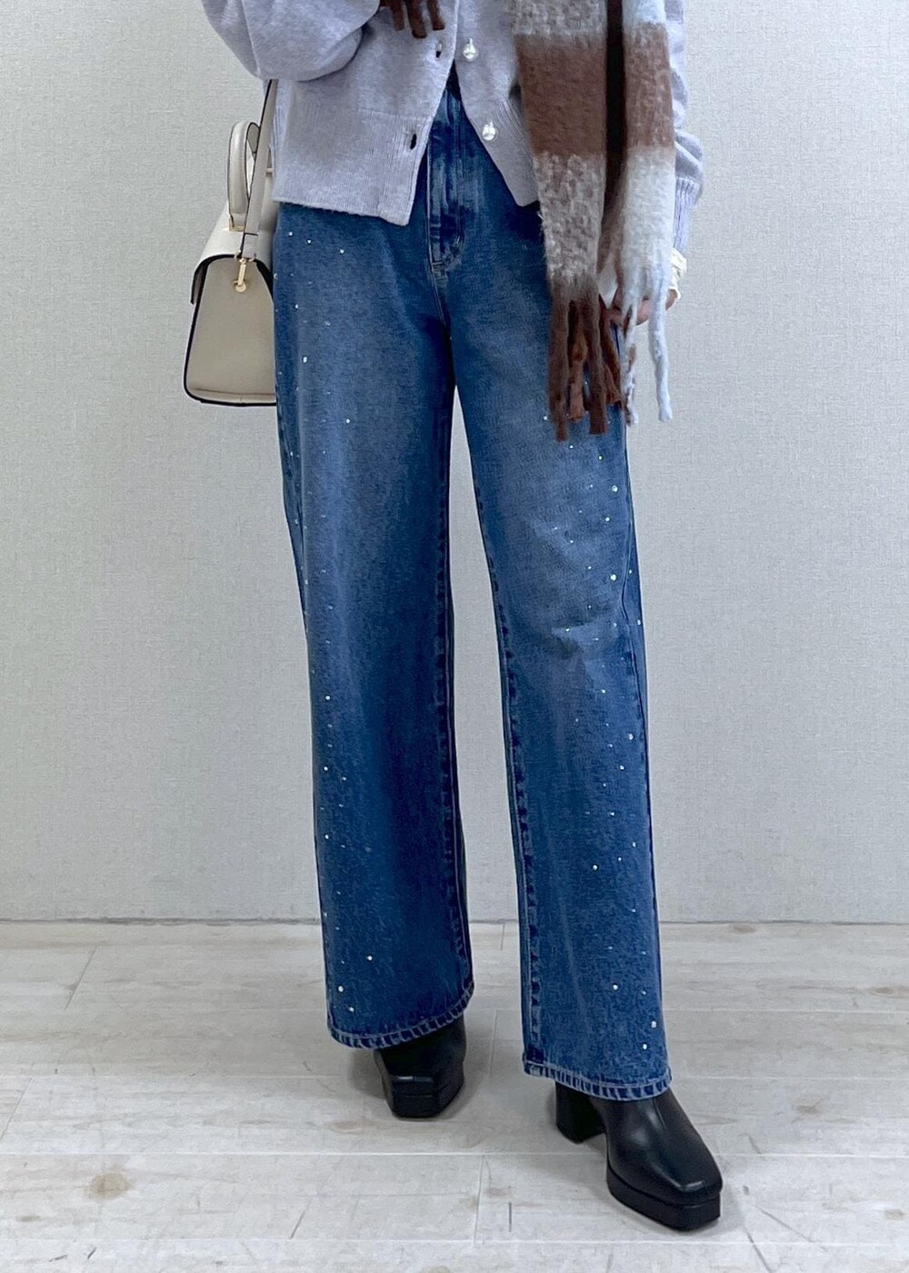 パープル系のカーディガン/ボレロ、ホワイト系のTシャツ/カットソー、ブラック系のブーツを着用したレディースの秋コーディネートの7枚目の写真