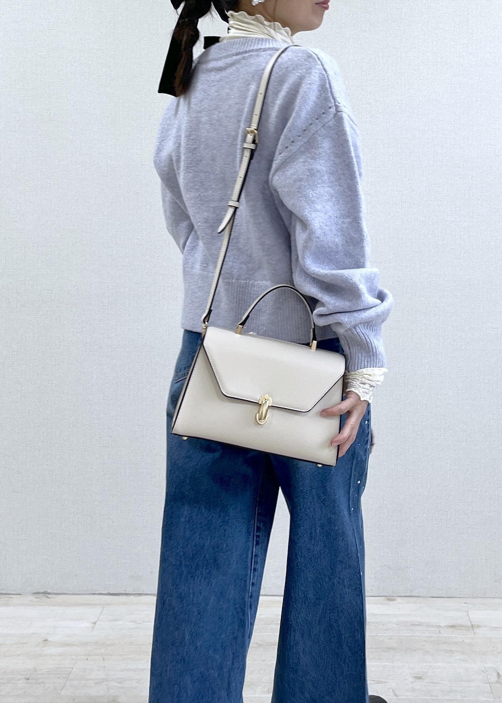 パープル系のカーディガン/ボレロ、ホワイト系のTシャツ/カットソー、ブラック系のブーツを着用したレディースの秋コーディネートの10枚目の写真