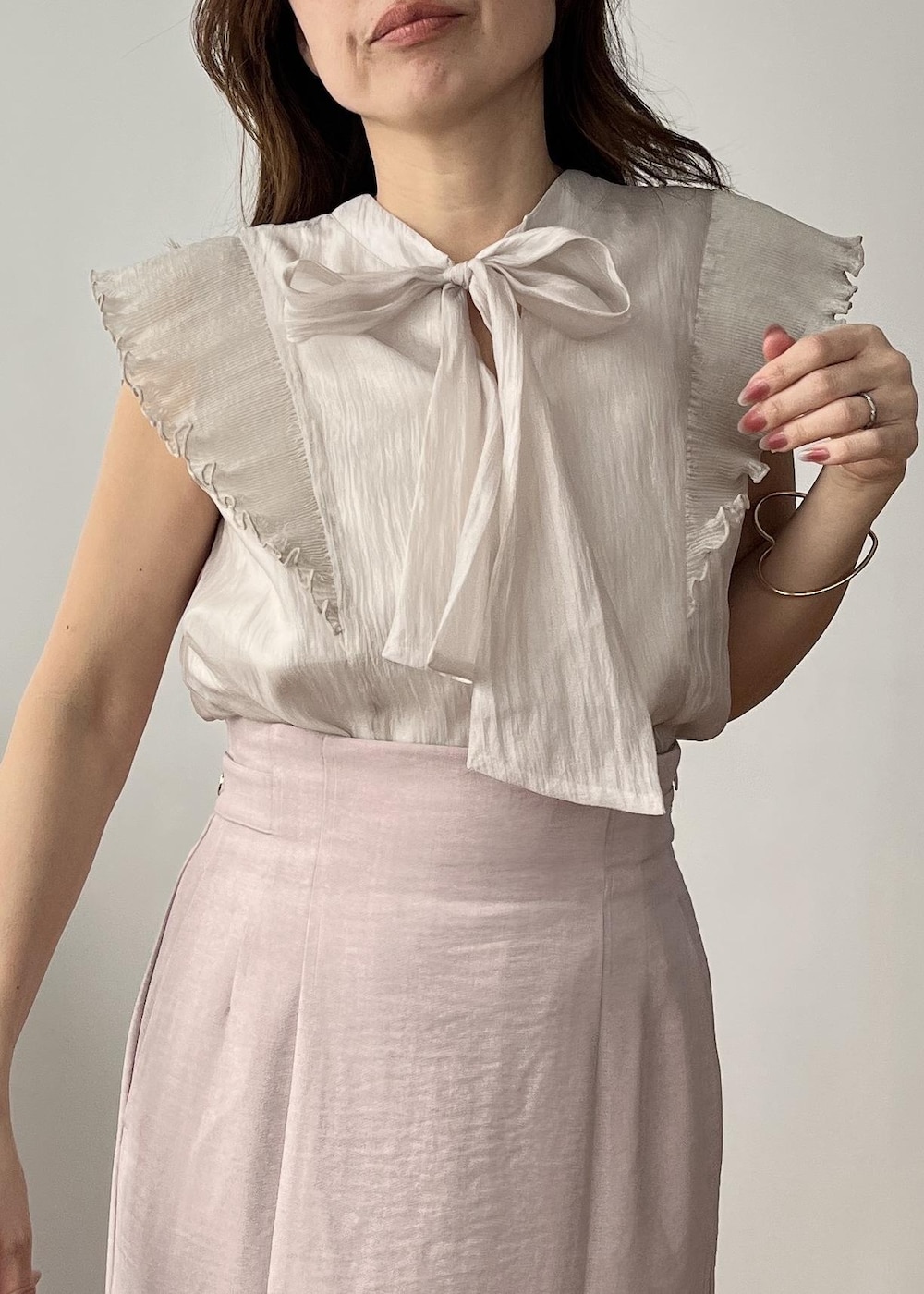 ベージュ系のショルダーバッグ、ピンク系のスカート、ホワイト系のサンダルを着用したレディースの春コーディネートの5枚目の写真