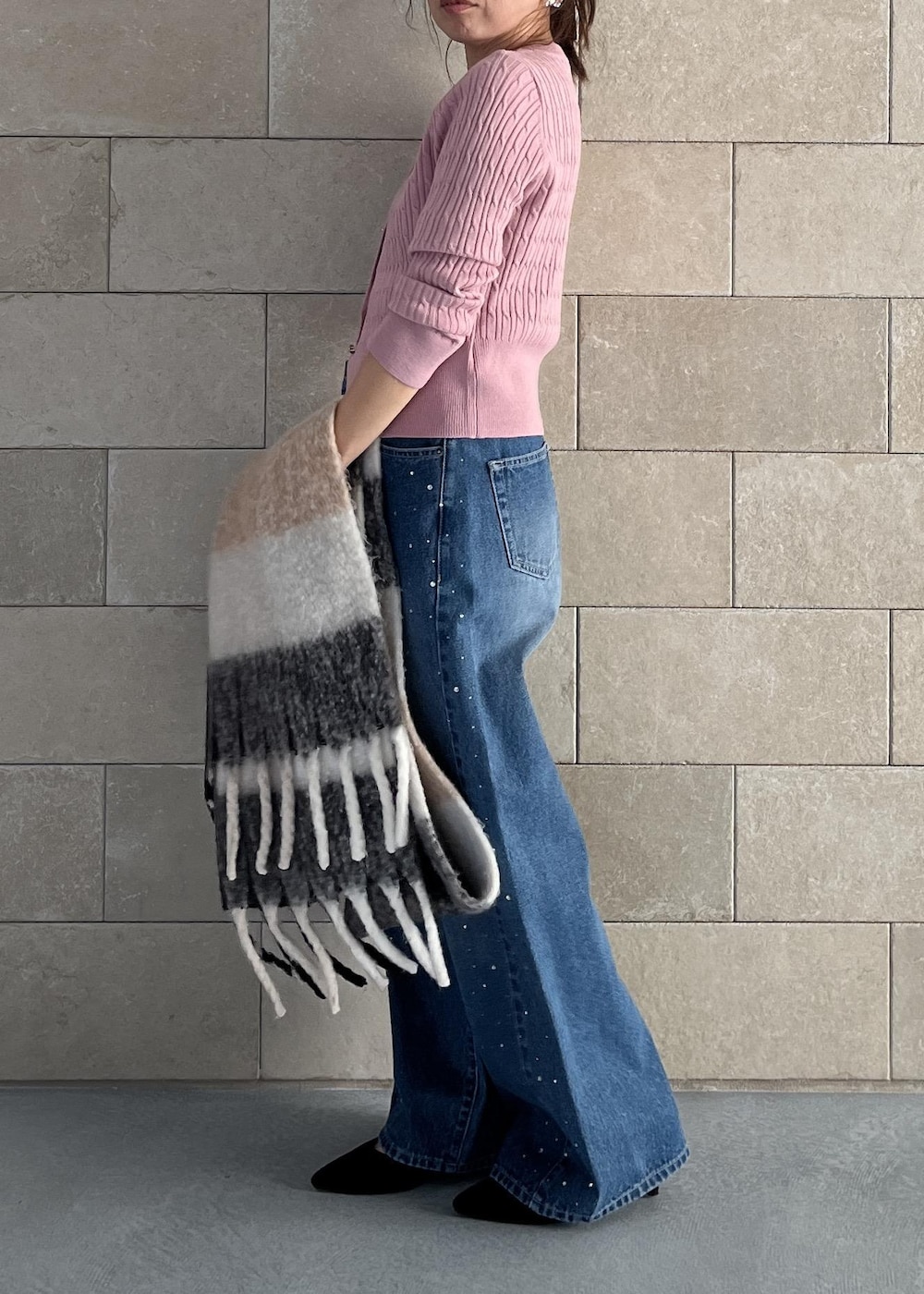 ブラック系のハンドバッグ、ピンク系のカーディガン/ボレロ、ブルー系のデニムパンツを着用したレディースの秋コーディネートの9枚目の写真