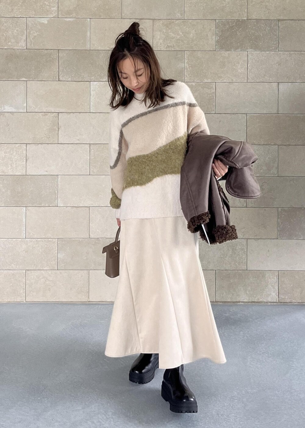 ベージュ系のショルダーバッグ、ブラック系のブーツ、ブラウン系のブルゾンを着用したレディースの秋コーディネートの10枚目の写真