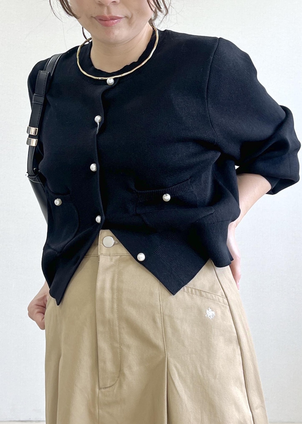 ブラック系のショルダーバッグ、ブラック系のカーディガン/ボレロ、ベージュ系のスカートを着用したレディースの春コーディネートの7枚目の写真