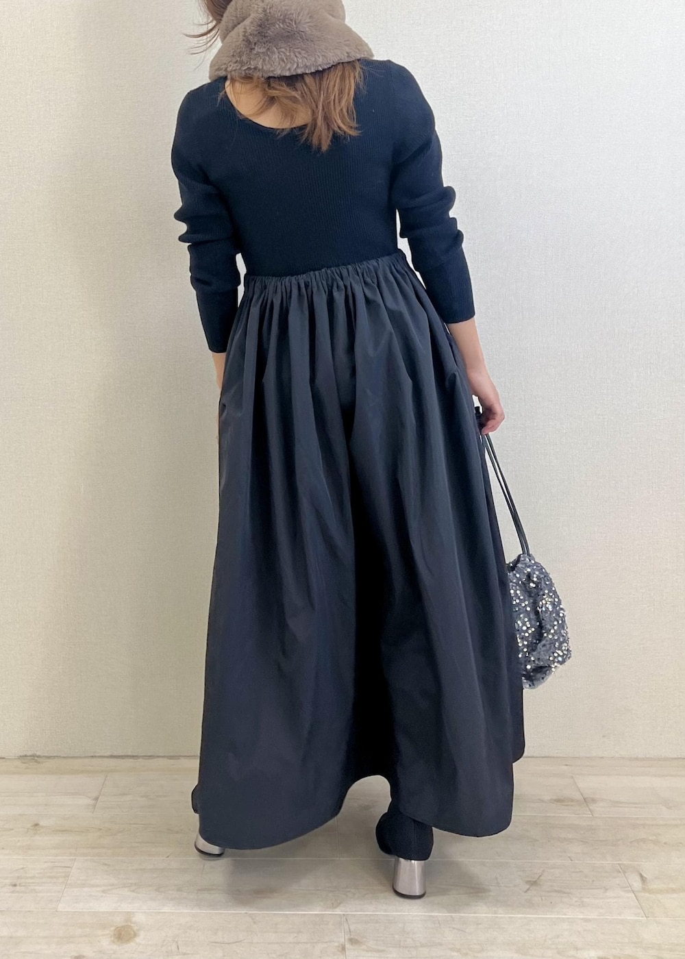 ブラック系のブーツ、シルバー系のハンドバッグ、ブラック系のワンピースを着用したレディースの冬コーディネートの3枚目の写真