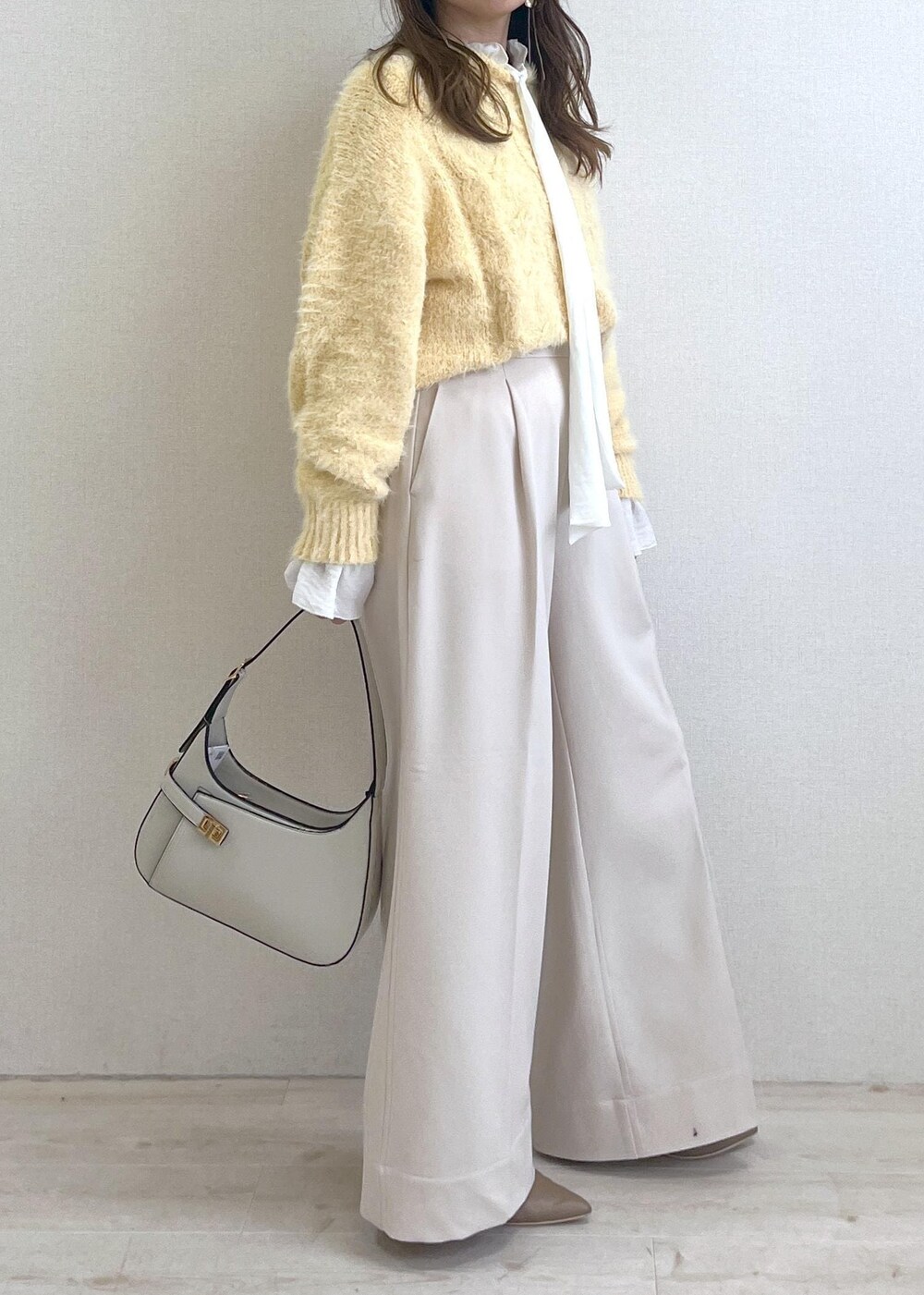ベージュ系のブーツ、ホワイト系のハンドバッグ、ホワイト系のシャツ/ブラウスを着用したレディースの秋コーディネートの3枚目の写真