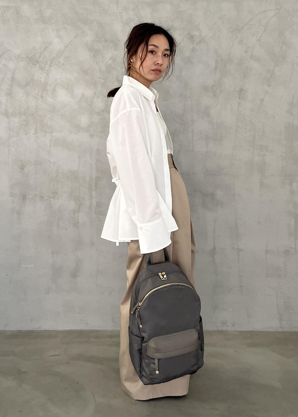 ブラック系のパンプス、ベージュ系のその他パンツ、グレー系のバックパック/リュックを着用したレディースの冬コーディネートの10枚目の写真