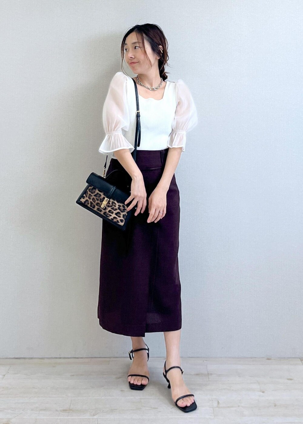 ブラック系のサンダル、ホワイト系のTシャツ/カットソー、ブラウン系のスカートを着用したレディースの夏コーディネートの3枚目の写真