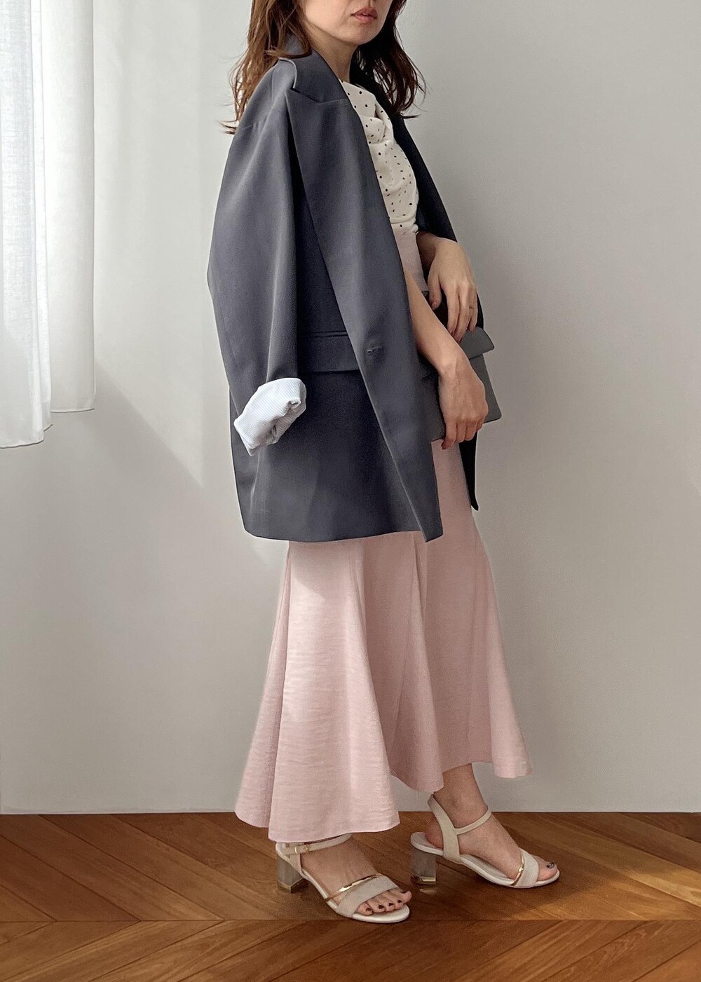 グレー系のショルダーバッグ、グレー系のテーラードジャケット、ピンク系のスカートを着用したレディースの春コーディネートの3枚目の写真