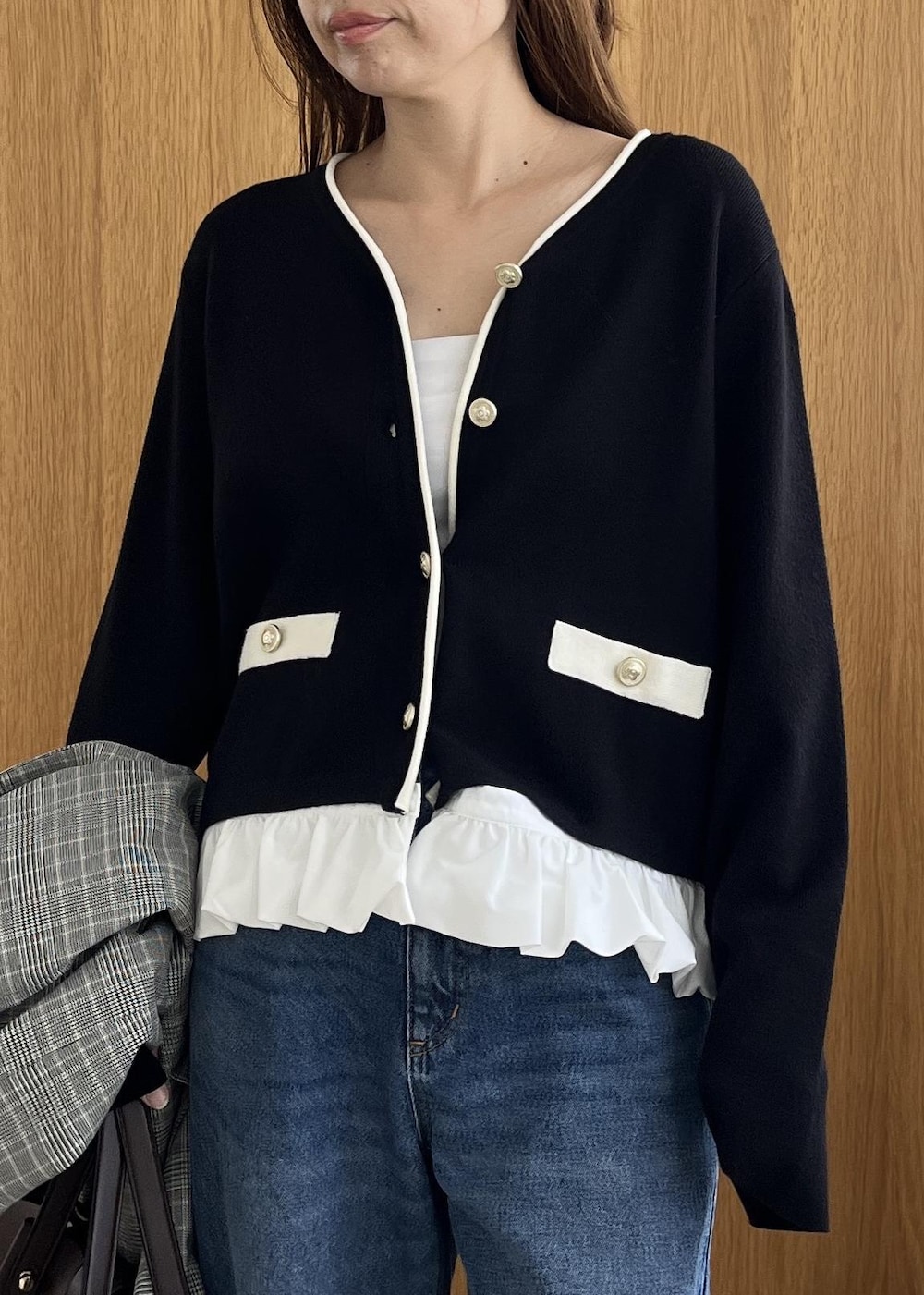 グレー系のテーラードジャケット、ブラウン系のビジネスバッグ、ブルー系のデニムパンツを着用したレディースの秋コーディネートの9枚目の写真