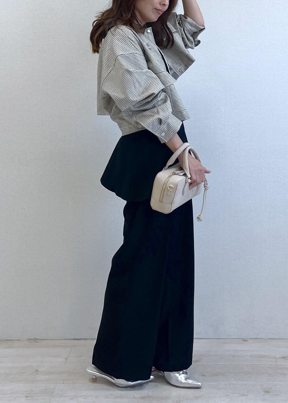 シルバー系のパンプス、ブラック系のキャミソール、ベージュ系のカバーオールを着用したレディースの秋コーディネートの7枚目の写真
