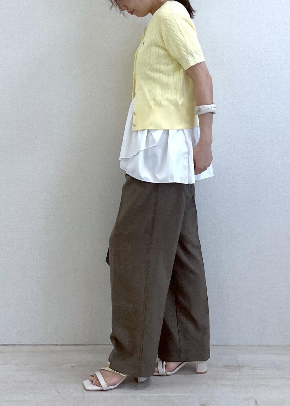 ホワイト系のサンダル、イエロー系のカーディガン/ボレロ、ホワイト系のTシャツ/カットソーを着用したレディースの夏コーディネートの2枚目の写真