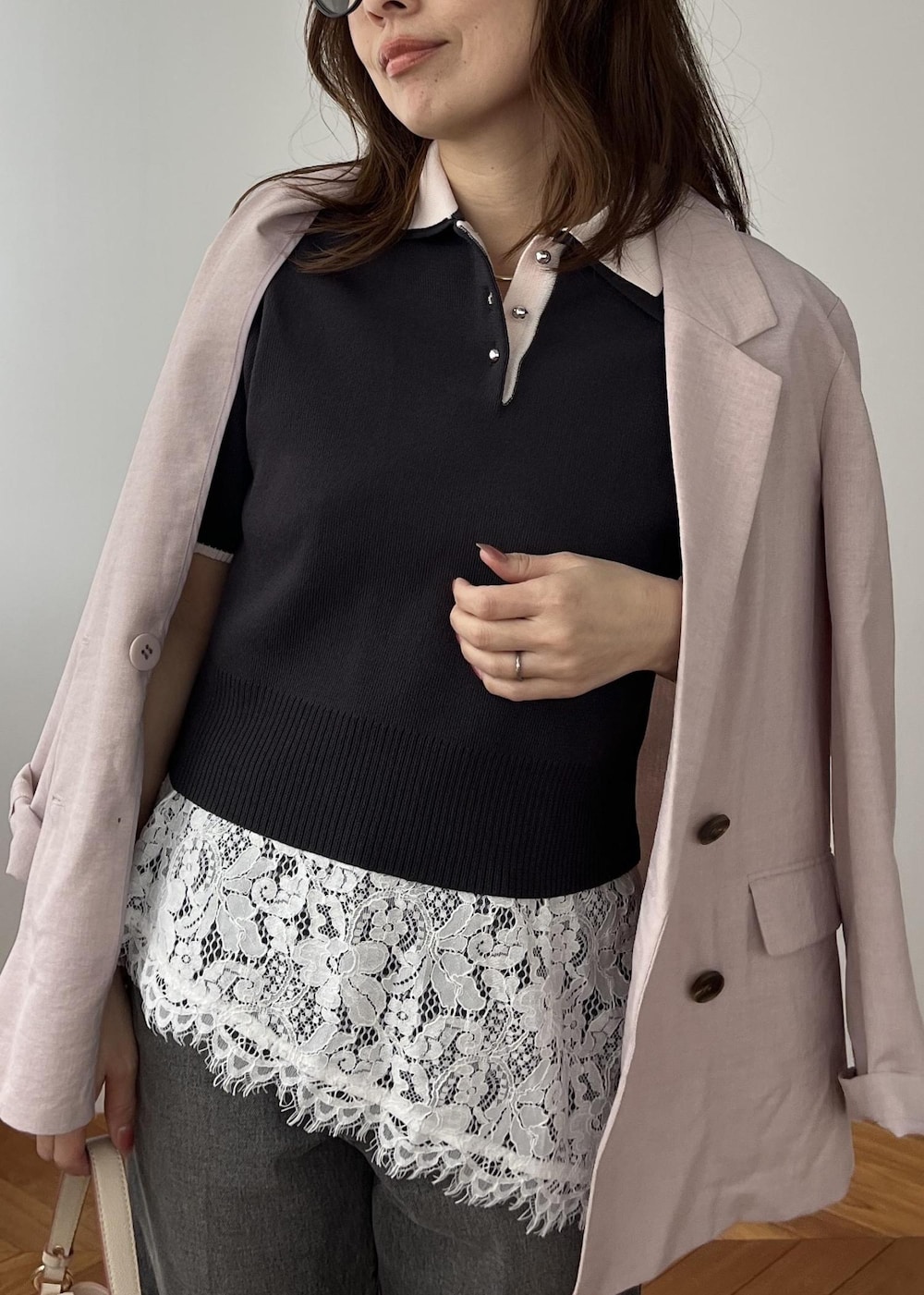 ベージュ系のショルダーバッグ、ピンク系のテーラードジャケット、グレー系のポロシャツを着用したレディースの春コーディネートの9枚目の写真