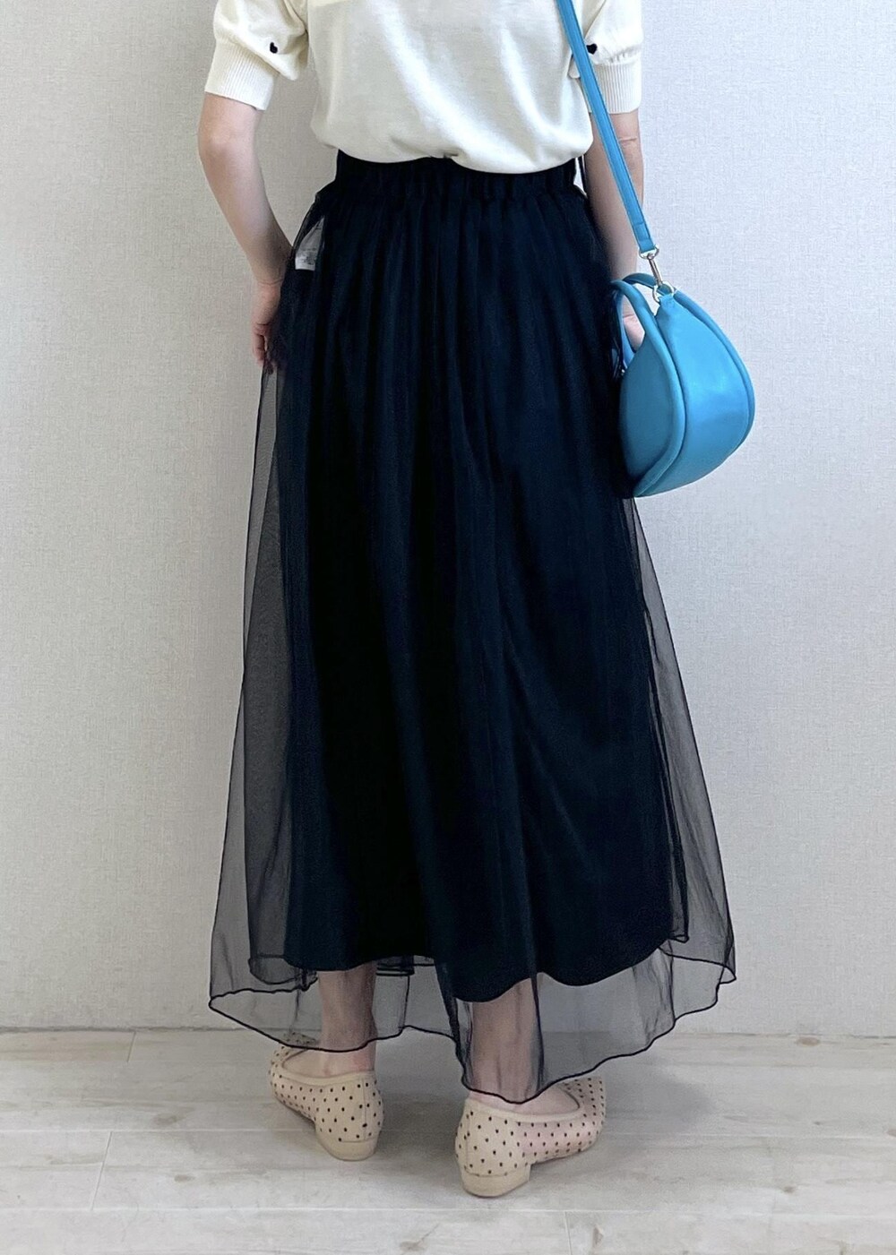 ベージュ系のパンプス、ブラック系のスカート、ホワイト系のニット/セーターを着用したレディースの春コーディネートの3枚目の写真