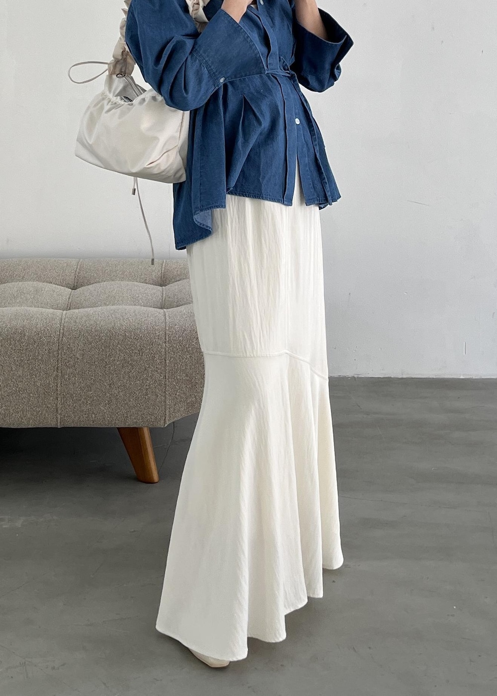 ホワイト系のショルダーバッグ、ホワイト系のパンプス、ホワイト系のスカートを着用したレディースの冬コーディネートの5枚目の写真