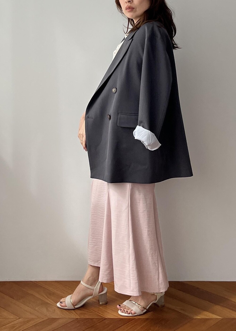 グレー系のショルダーバッグ、グレー系のテーラードジャケット、ピンク系のスカートを着用したレディースの春コーディネートの2枚目の写真