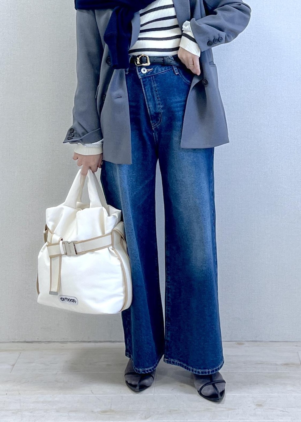 グレー系のテーラードジャケット、ブルー系のデニムパンツ、ホワイト系のニット/セーターを着用したレディースの冬コーディネートの2枚目の写真