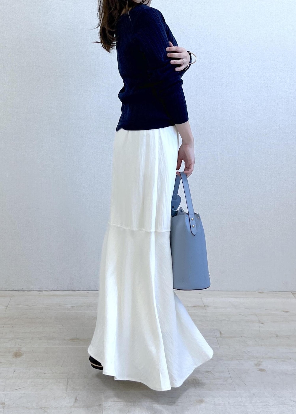 ブラック系のパンプス、ブルー系のショルダーバッグ、ベージュ系のトレンチコートを着用したレディースの春コーディネートの3枚目の写真