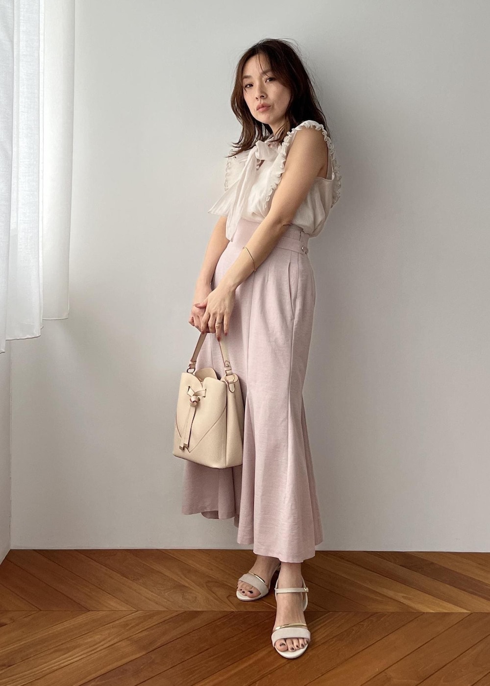 ベージュ系のショルダーバッグ、ピンク系のスカート、ホワイト系のサンダルを着用したレディースの春コーディネートの8枚目の写真