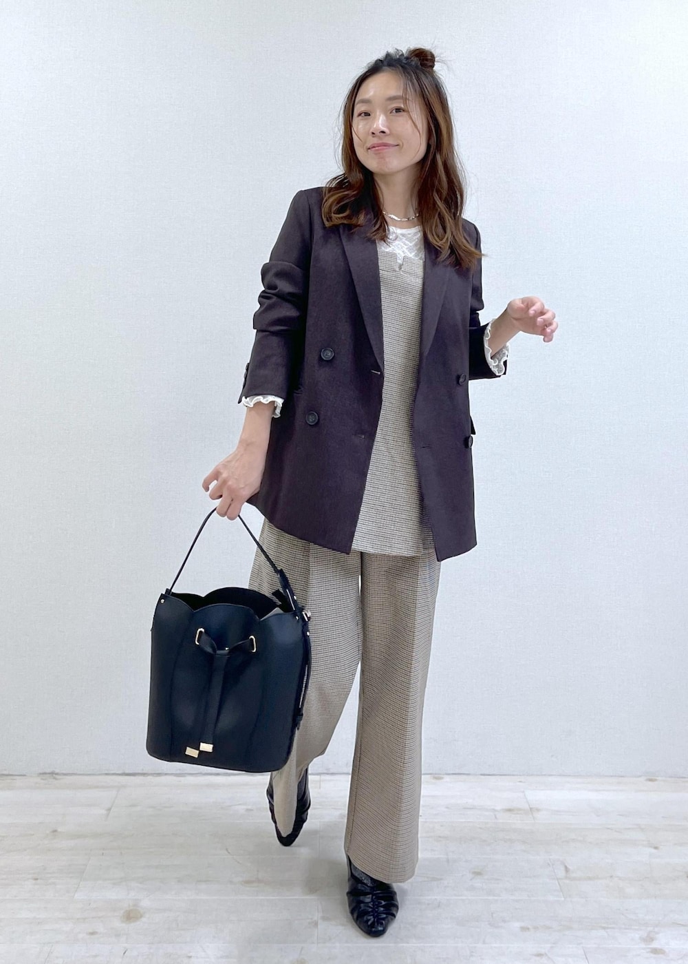 ベージュ系のスラックス、ブラウン系のテーラードジャケット、ベージュ系のキャミソールを着用したレディースの秋コーディネートの10枚目の写真