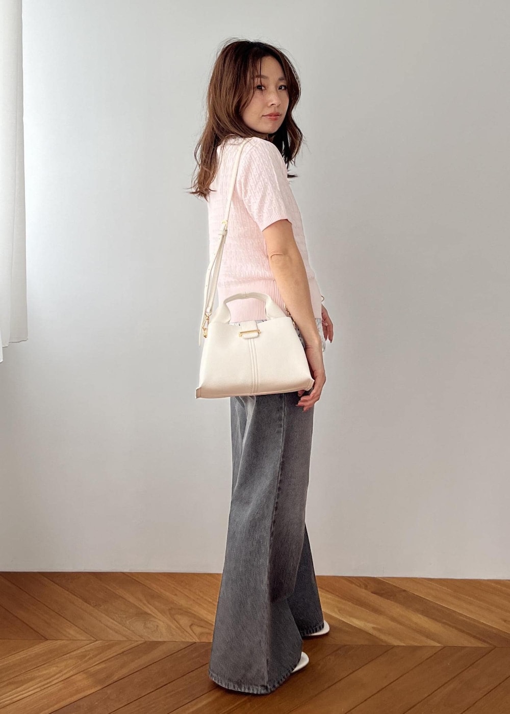 ホワイト系のキャミソール、ブラック系のデニムパンツ、ホワイト系のショルダーバッグを着用したレディースの春コーディネートの9枚目の写真