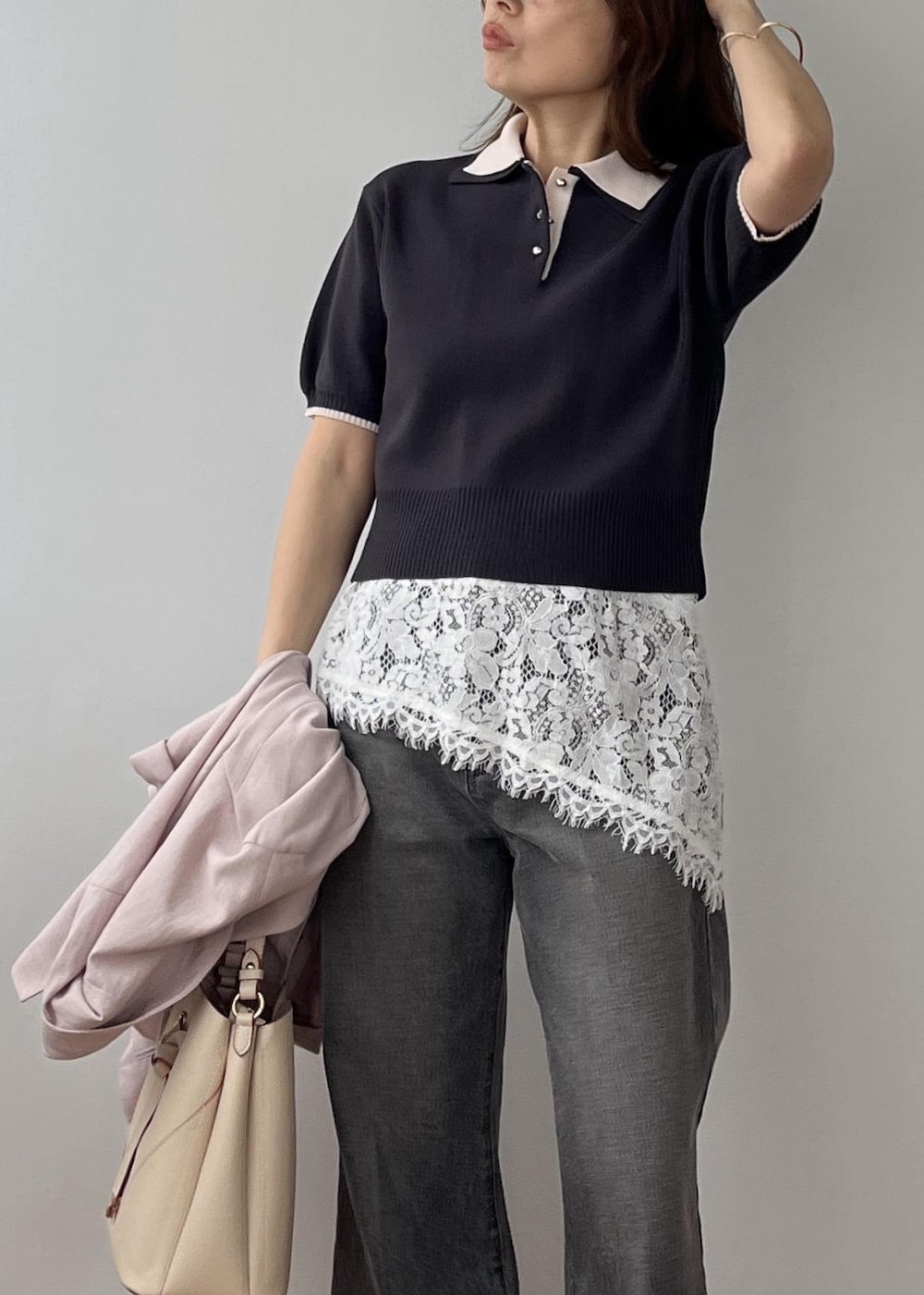 ベージュ系のショルダーバッグ、ピンク系のテーラードジャケット、グレー系のポロシャツを着用したレディースの春コーディネートの5枚目の写真