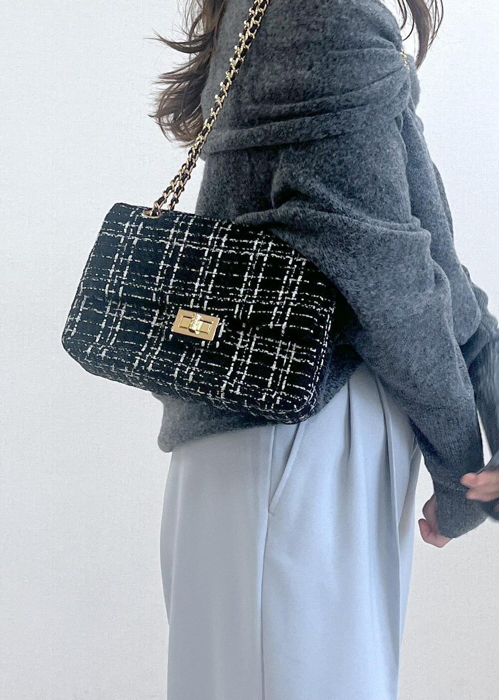 グレー系のドレスシューズ、ブラック系のショルダーバッグ、グレー系のニット/セーターを着用したレディースの秋コーディネートの5枚目の写真