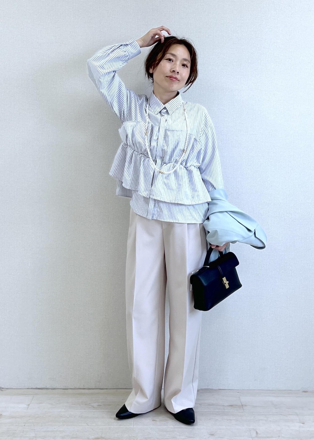 ブラック系のショルダーバッグ、グリーン系のテーラードジャケット、ベージュ系のその他パンツを着用したレディースの春コーディネートの7枚目の写真