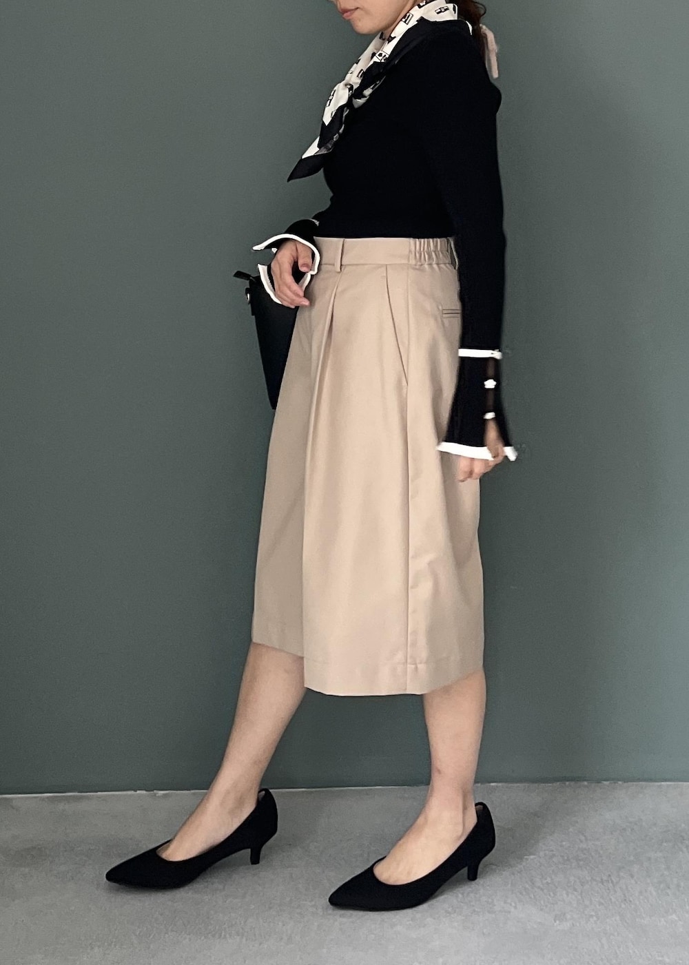 ベージュ系のその他パンツ、ブラック系のトートバッグ、ブラック系のニット/セーターを着用したレディースの秋コーディネートの2枚目の写真