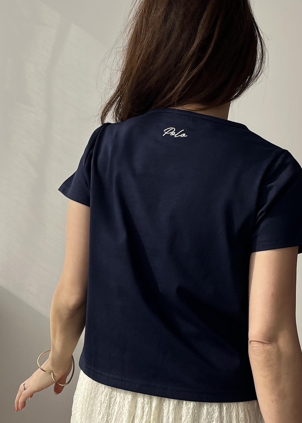 ホワイト系のスカート、ブラック系のショルダーバッグ、ホワイト系のサンダルを着用したレディースの春コーディネートの8枚目の写真