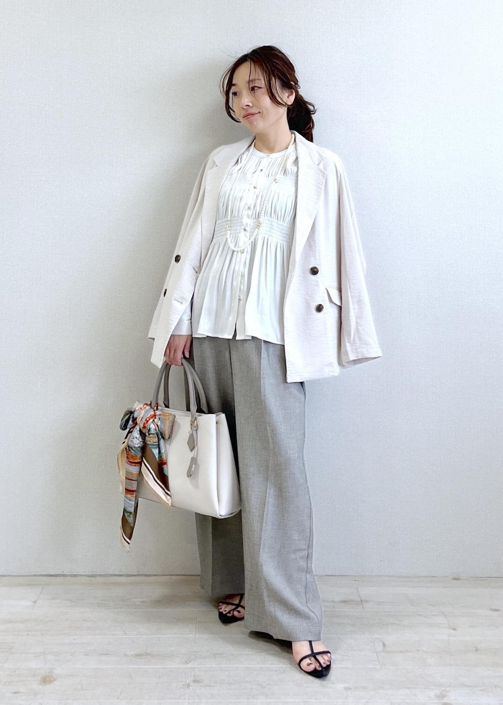 ホワイト系のシャツ/ブラウス、グレー系のその他パンツ、ホワイト系のテーラードジャケットを着用したレディースの春コーディネートの6枚目の写真