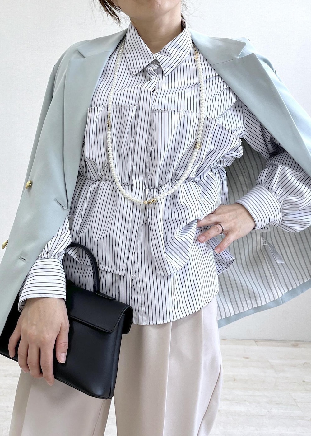 ブラック系のショルダーバッグ、グリーン系のテーラードジャケット、ベージュ系のその他パンツを着用したレディースの春コーディネートの5枚目の写真