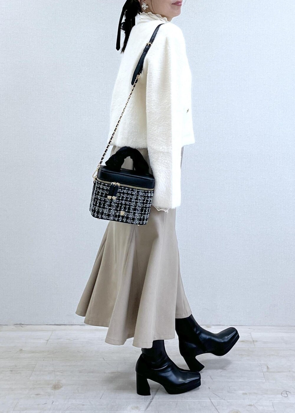 ベージュ系のスカート、ホワイト系のカーディガン/ボレロ、ホワイト系のTシャツ/カットソーを着用したレディースの秋コーディネートの3枚目の写真