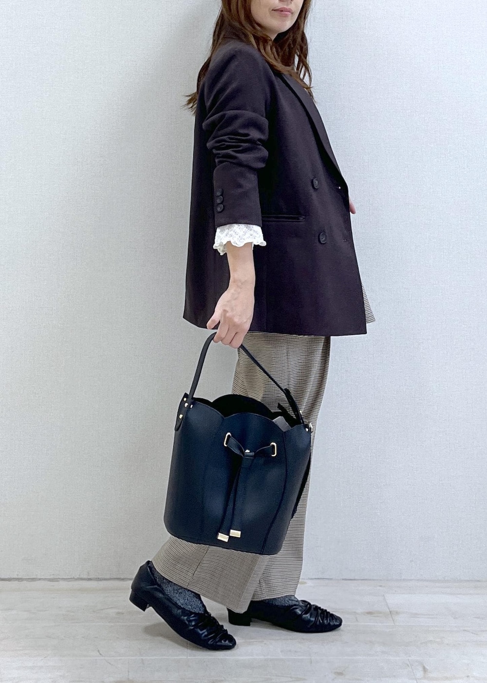 ベージュ系のスラックス、ブラウン系のテーラードジャケット、ベージュ系のキャミソールを着用したレディースの秋コーディネートの3枚目の写真