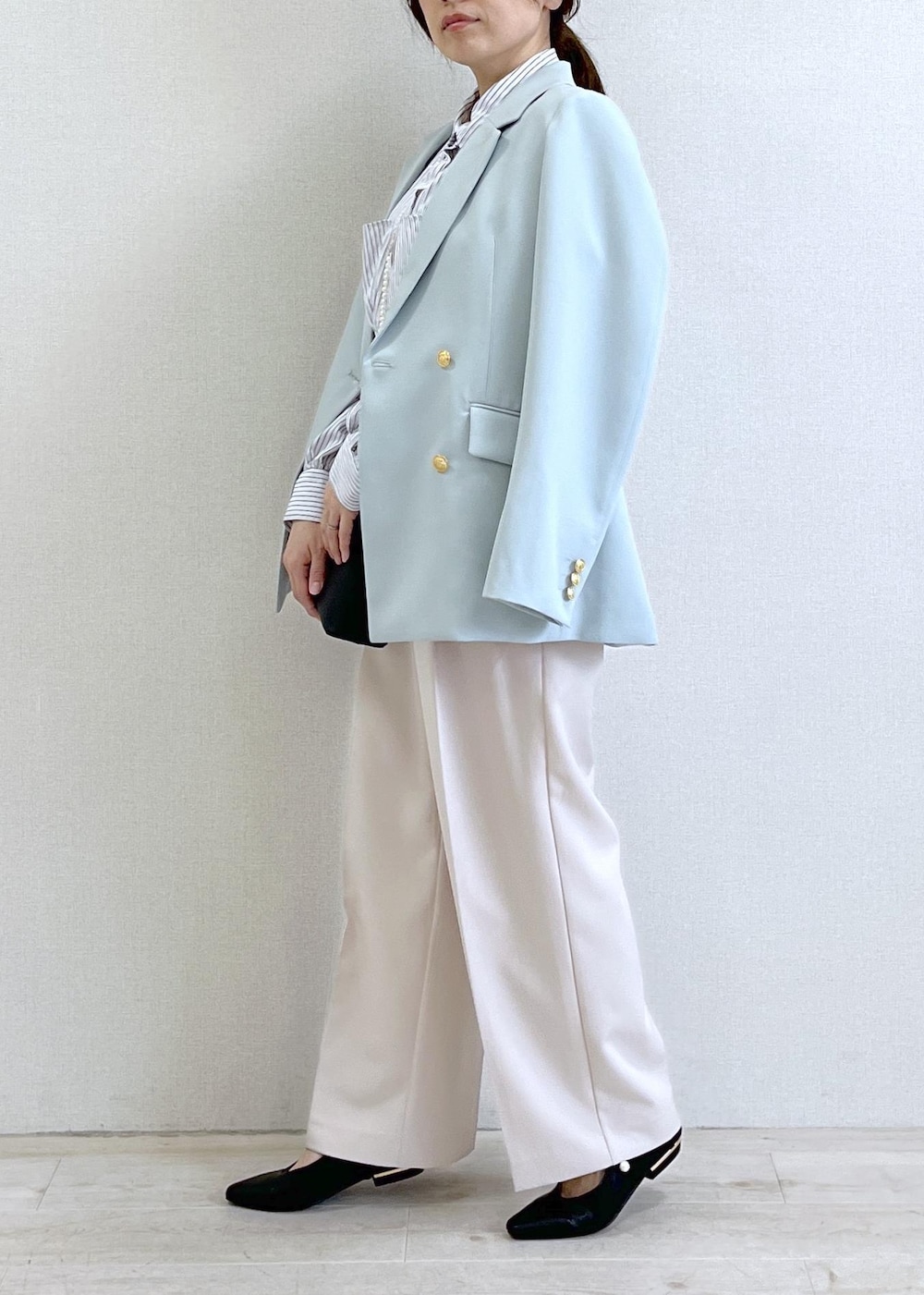 ブラック系のショルダーバッグ、グリーン系のテーラードジャケット、ベージュ系のその他パンツを着用したレディースの春コーディネートの3枚目の写真