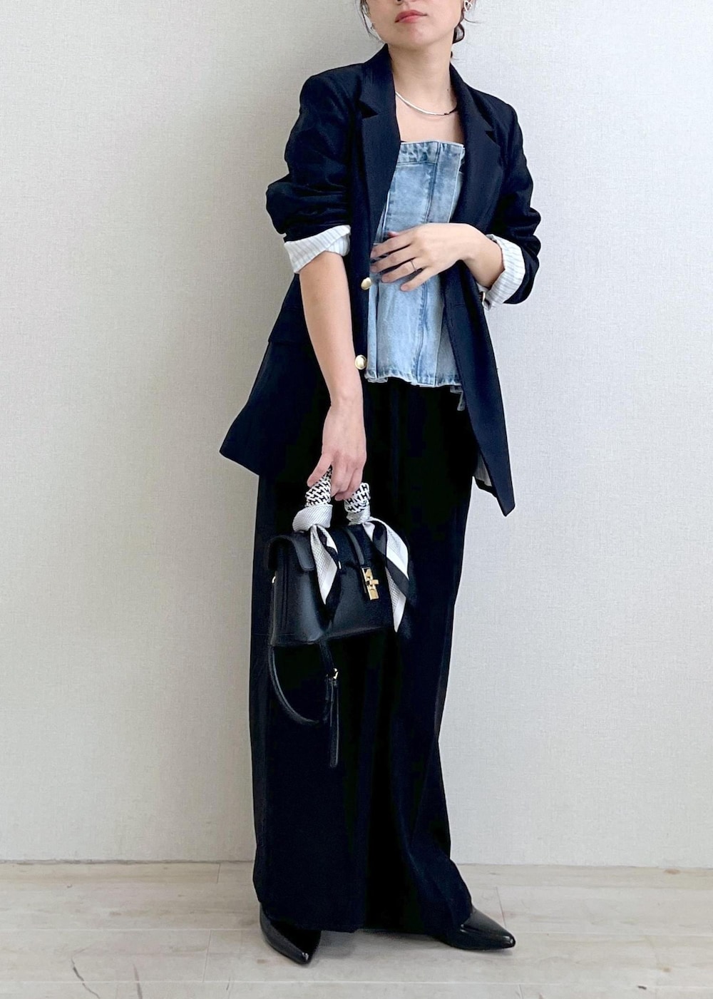 ブラック系のショルダーバッグ、ブルー系のキャミソール、ブルー系のスラックスを着用したレディースの冬コーディネートの3枚目の写真