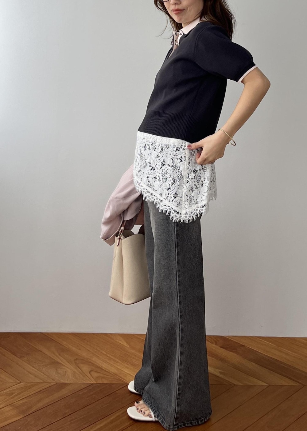 ベージュ系のショルダーバッグ、ピンク系のテーラードジャケット、グレー系のポロシャツを着用したレディースの春コーディネートの3枚目の写真