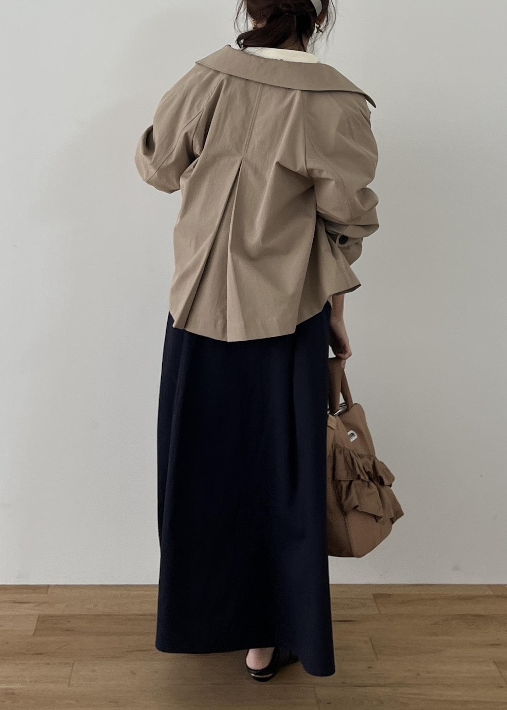 ブラック系のパンプス、ベージュ系のトートバッグ、ベージュ系のトレンチコートを着用したレディースの冬コーディネートの5枚目の写真