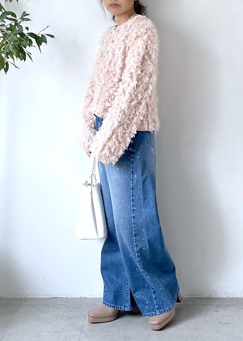 ホワイト系のショルダーバッグ、ベージュ系のブーツ、ピンク系のニット/セーターを着用したレディースの秋コーディネートの3枚目の写真