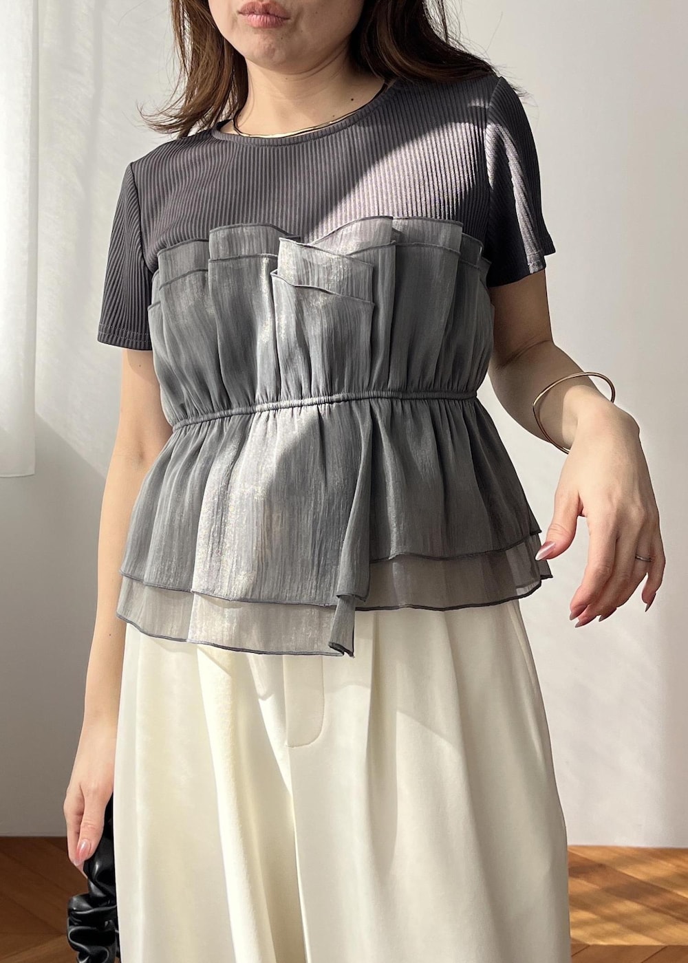 ホワイト系のスラックス、ブラック系のショルダーバッグ、ホワイト系のサンダルを着用したレディースの春コーディネートの6枚目の写真