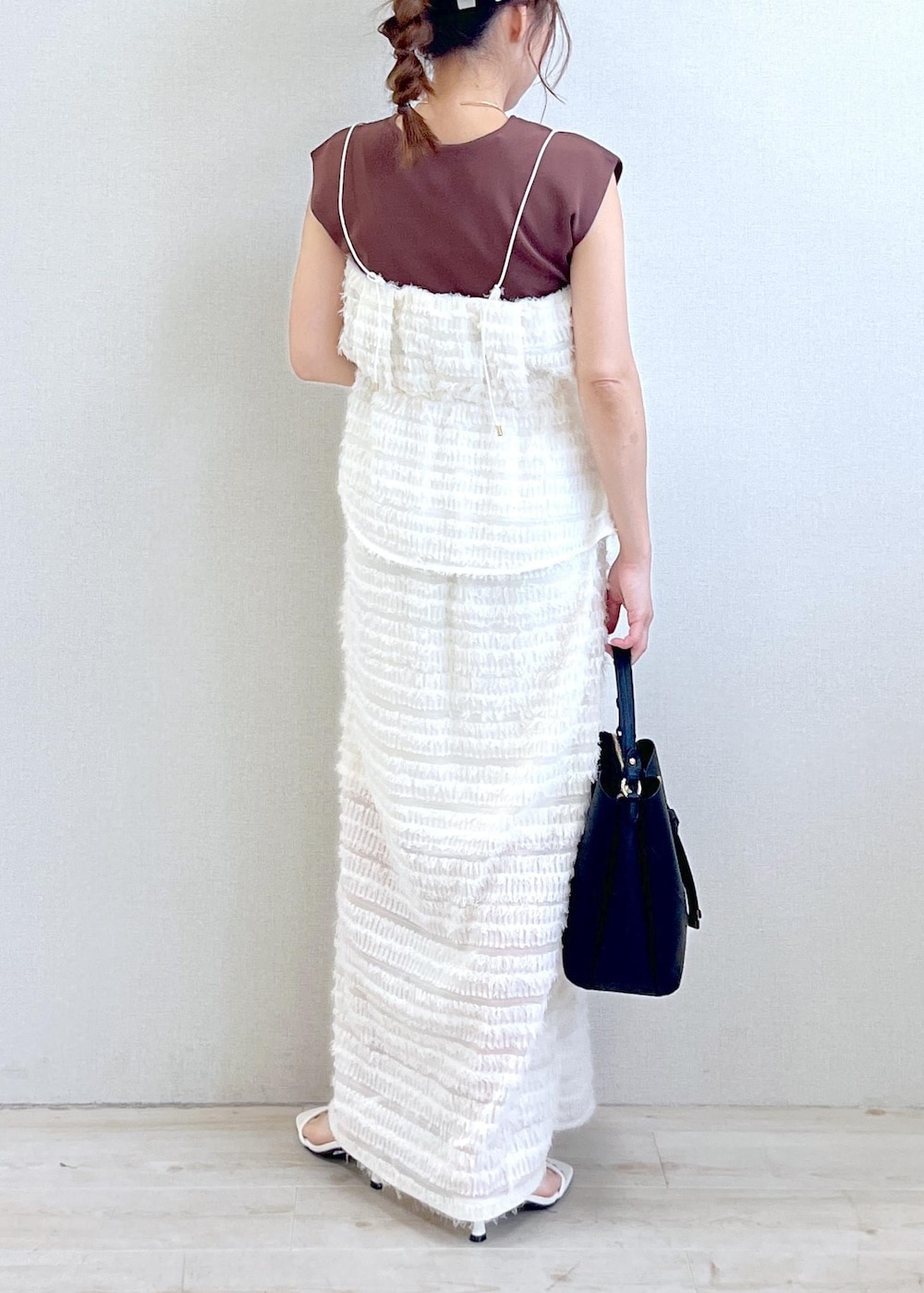 ブラック系のハンドバッグ、ホワイト系のサンダル、ブラウン系のニット/セーターを着用したレディースの春コーディネートの3枚目の写真