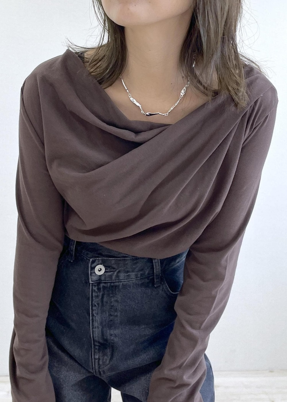 グレー系のショルダーバッグ、ブラウン系のTシャツ/カットソー、グレー系のデニムパンツを着用したレディースの秋コーディネートの6枚目の写真