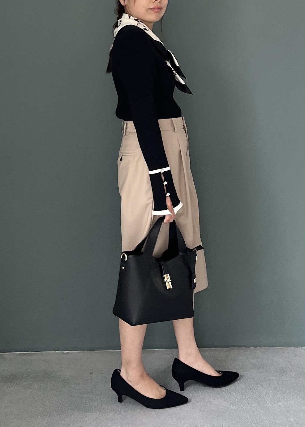 ベージュ系のその他パンツ、ブラック系のトートバッグ、ブラック系のニット/セーターを着用したレディースの秋コーディネートの4枚目の写真