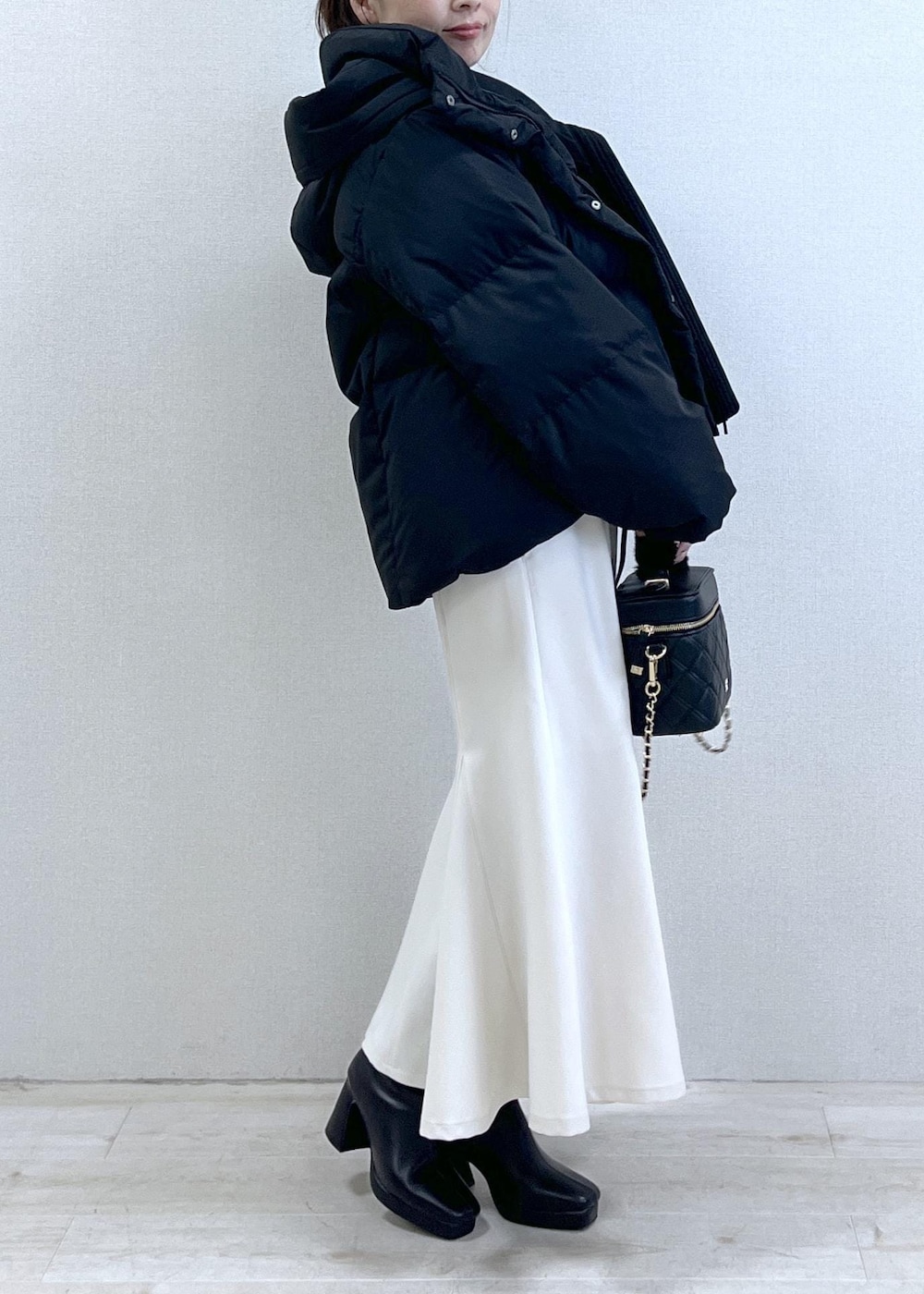 ブラック系のニット/セーター、ブラック系のダウンジャケット/コート、ブラック系のブーツを着用したレディースの冬コーディネートの7枚目の写真