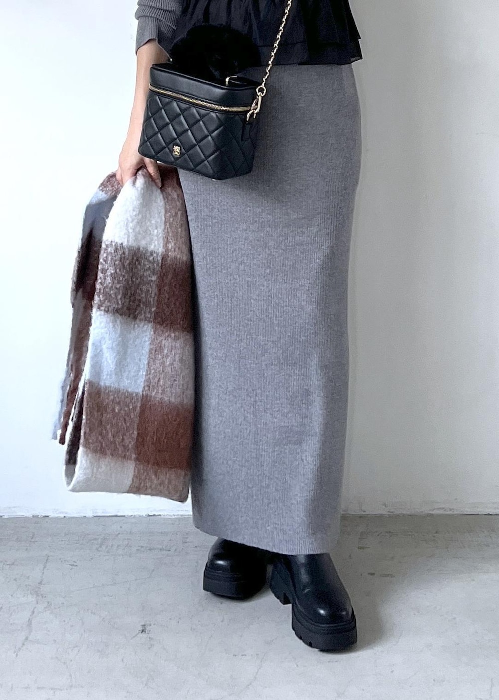 ブラック系のブーツ、グレー系のスカート、グレー系のニット/セーターを着用したレディースの秋コーディネートの8枚目の写真